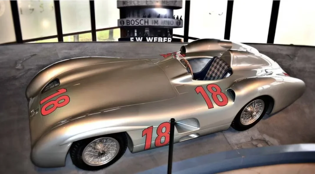 Juan Manuel Fangio al volante de un Mercedes-Benz W196, conocido como Flecha de Plata, en un circuito de carreras.