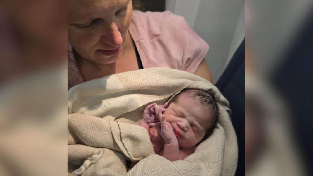 Bebé recién nacida en un vuelo de Delta Air Lines, sostenida por una paramédica