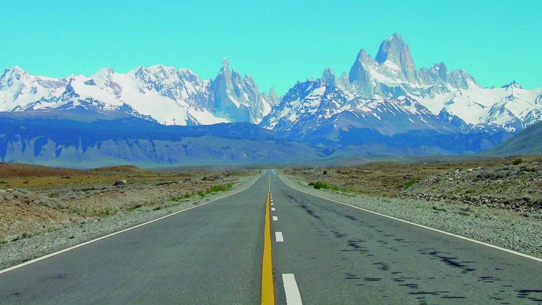 Persona consultando un celular y un mapa, representando la planificación de viajes en la era digital.